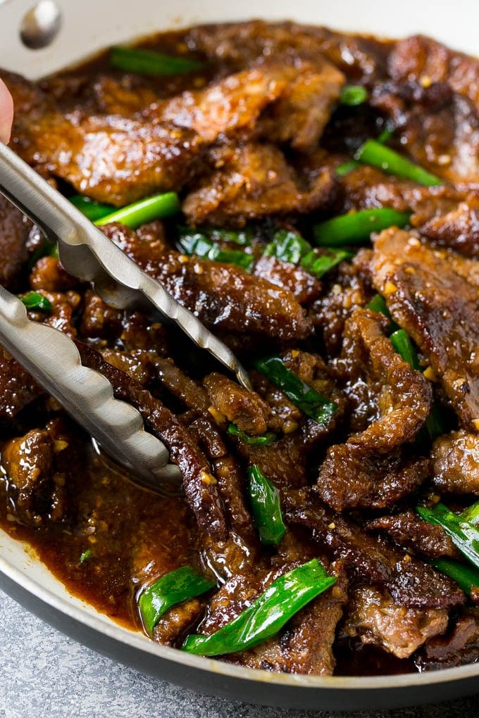 Mongolian Beef Recipe | Asian Beef Recipe | Chinese Beef | Beef Stir Fry #Chinese #Mongolian #Asian #mongolianbeef #beef #dinneratthezoo #dinner A pan of Mongolian beef with tongs in it.
